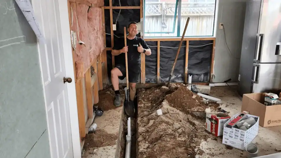 Man digging trench in home renovation project