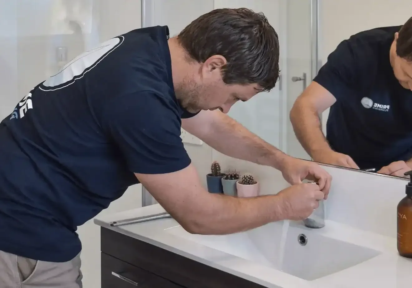 Plumber repairing bathroom sink faucet